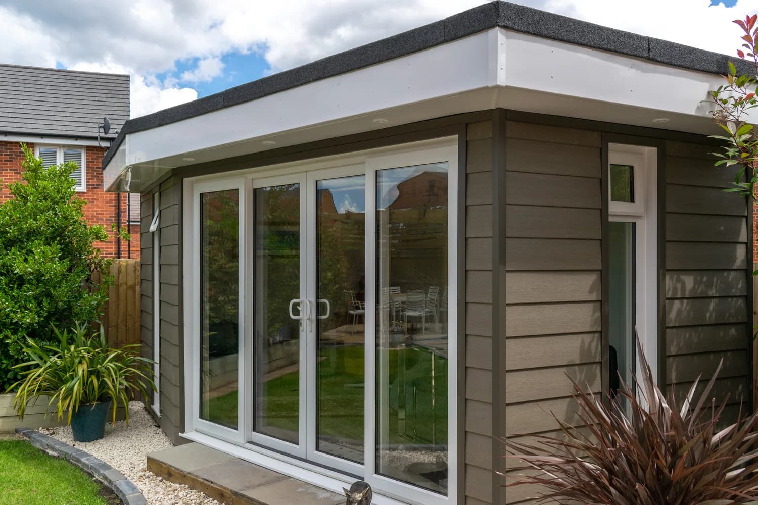 Modern garden build with grey cladding and glazed doors