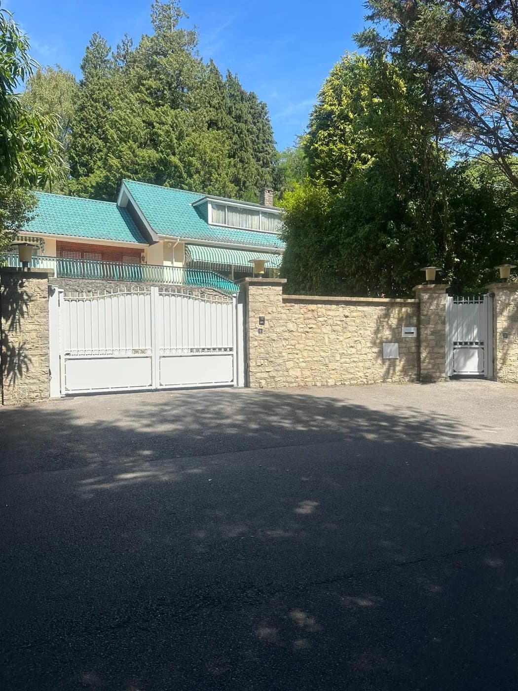 White driveway gates and pedestrian access gate at residential property